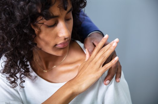 woman pushing coworkers hand off her shoulder